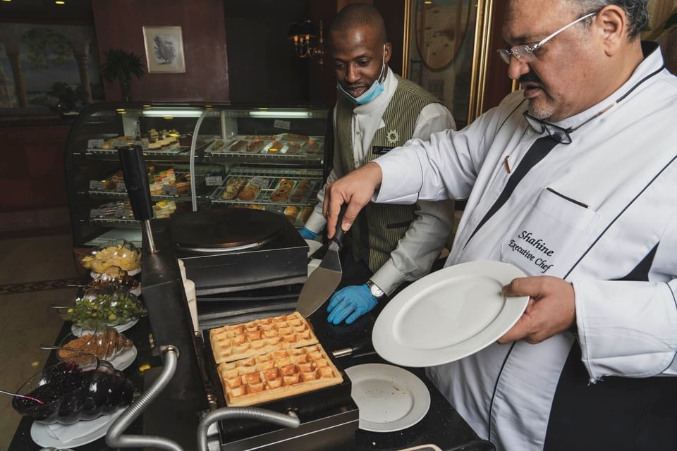 A man taking a waffle from a waffle toaster