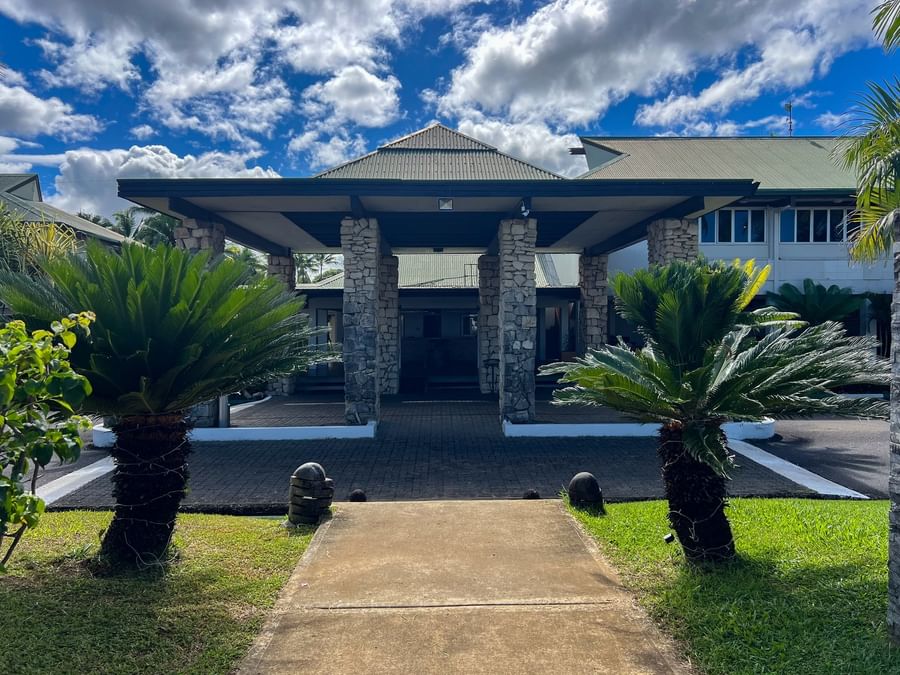 Stone pillars supporting a grand portico entrance by lush green sago palms at TokaToka Resort Nadi Fiji