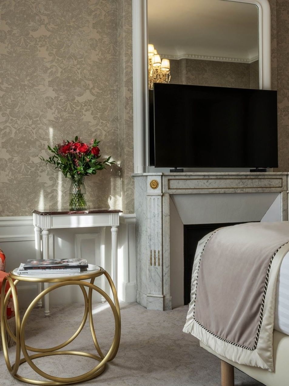 TV facing bed with couch near patterned coffee table in Prestige Suite – Rue de la Paix View at Hotel Westminster Paris