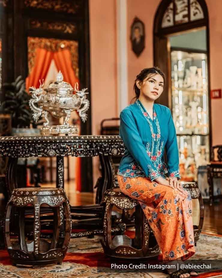 Woman styled in Nyonya Kebaya sat on the chair - Lexis Suites Penang 