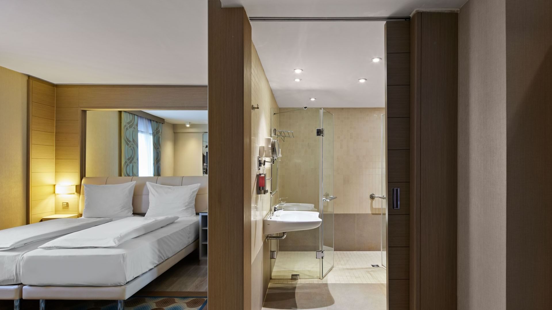 Separated bathroom and bedroom with modern fittings and furniture in Superior Room at Titanic Comfort Mitte