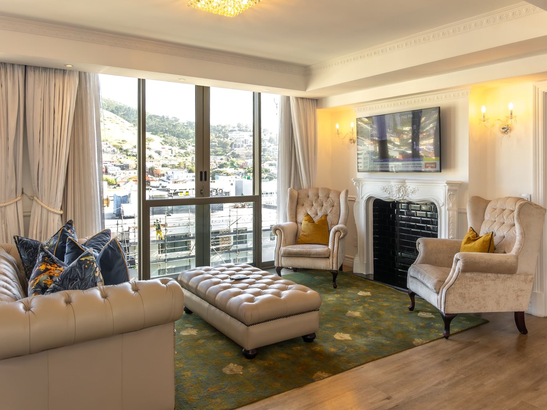 Elegant living room with tufted furniture, fireplace, and city views in Premier Two Bedroom Suite at Pepperclub Hotel