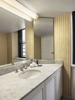 Speciality Suite bathroom featuring a marble vanity with a mirror by the window at Warwick Allerton Chicago