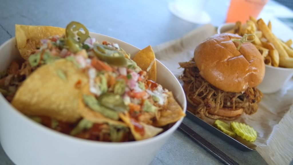 Close-up of pulled pork burger served with nachos in Bark ‘N Brine at Camp Creek Inn