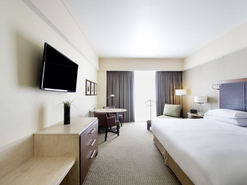 Master Suite, 1 King with a large bed, a wall-mounted TV, a work desk, an armchair at Grand Fiesta Americana