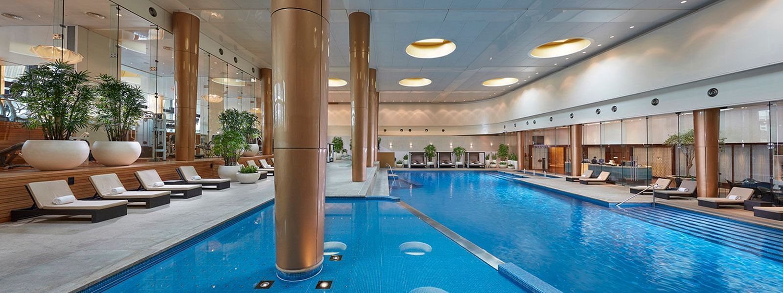 Indoor swimming pool with sunbeds at Crown Hotels Group