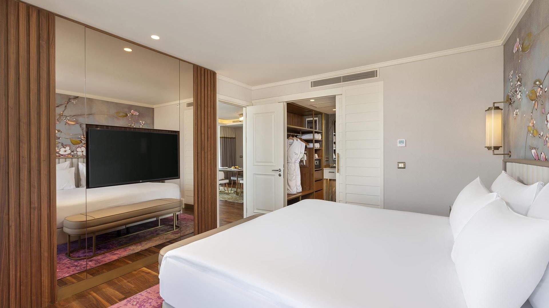 Titanic Port Bakırköy'de, çift kişilik bir yatak, bir ayna, yatak ucu pufu ve televizyonun bulunduğu Suite oda.