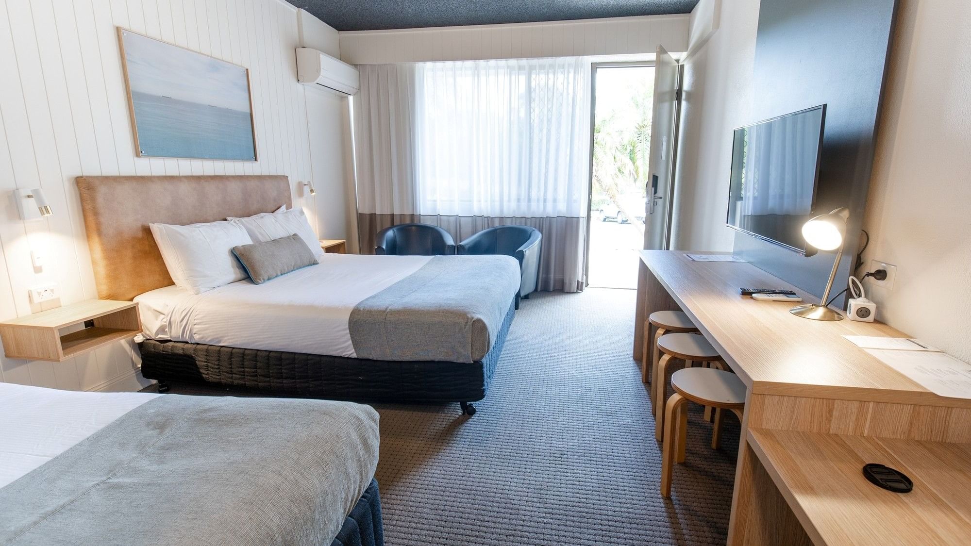 Comfortable hotel room with two beds, a desk, and a balcony at Mercure Charlestown.