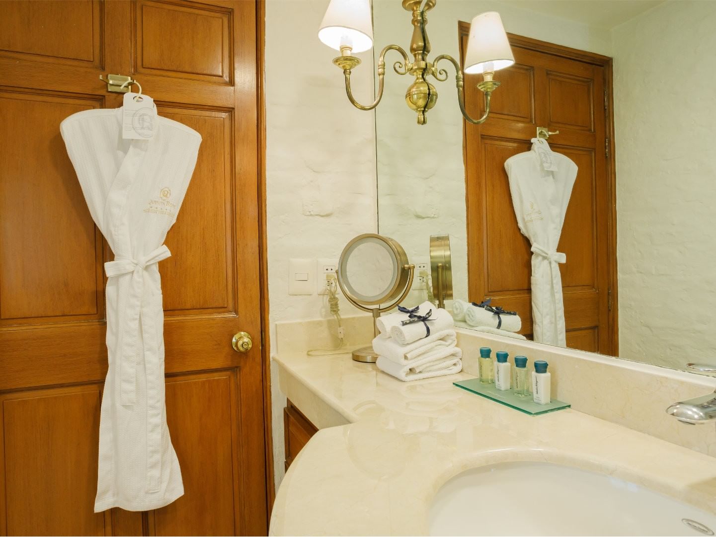 King Presidential Suite White waffle robe, and luxury toiletries on a marble counter at Quinta Real Guadalajara