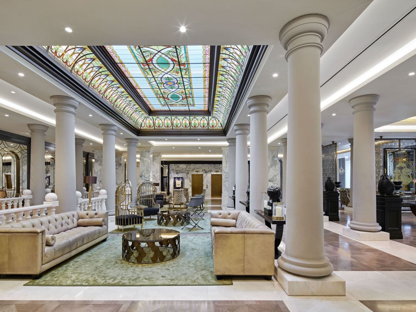 Die elegante Lobby mit Plüschsitzen und imposanten Säulen im Titanic Gendarmenmarkt Berlin.