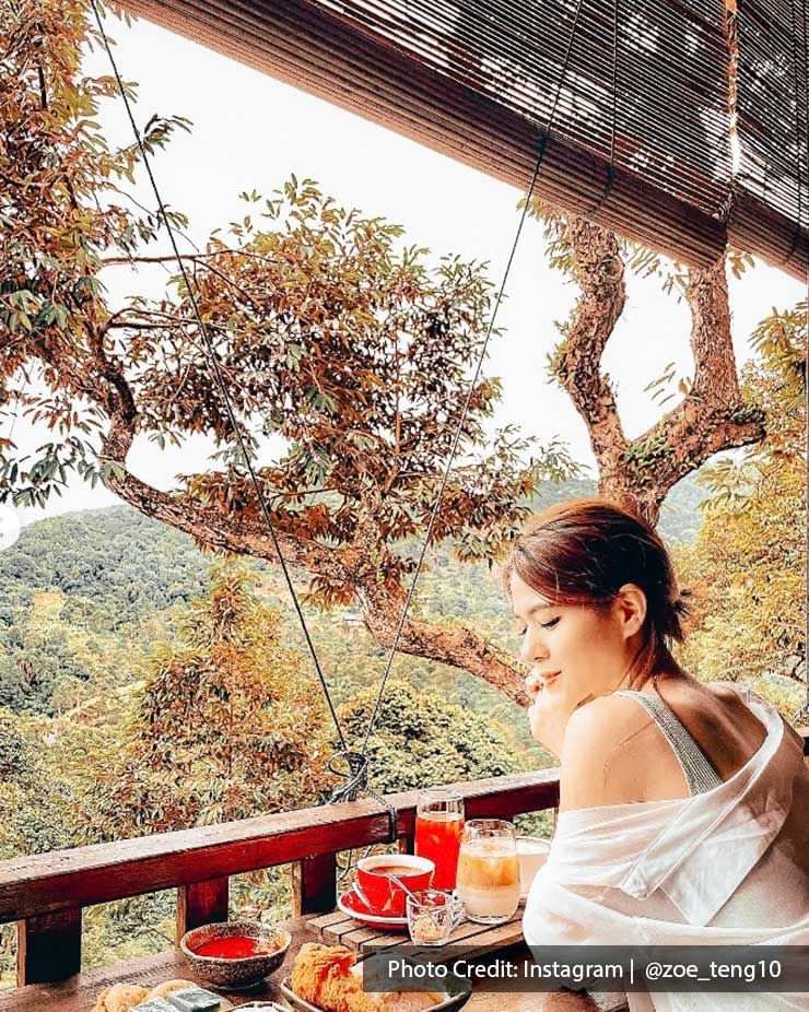 A lady was taking a picture with her dishes at Bao Sheng Durian Farm - Lexis Suites Penang