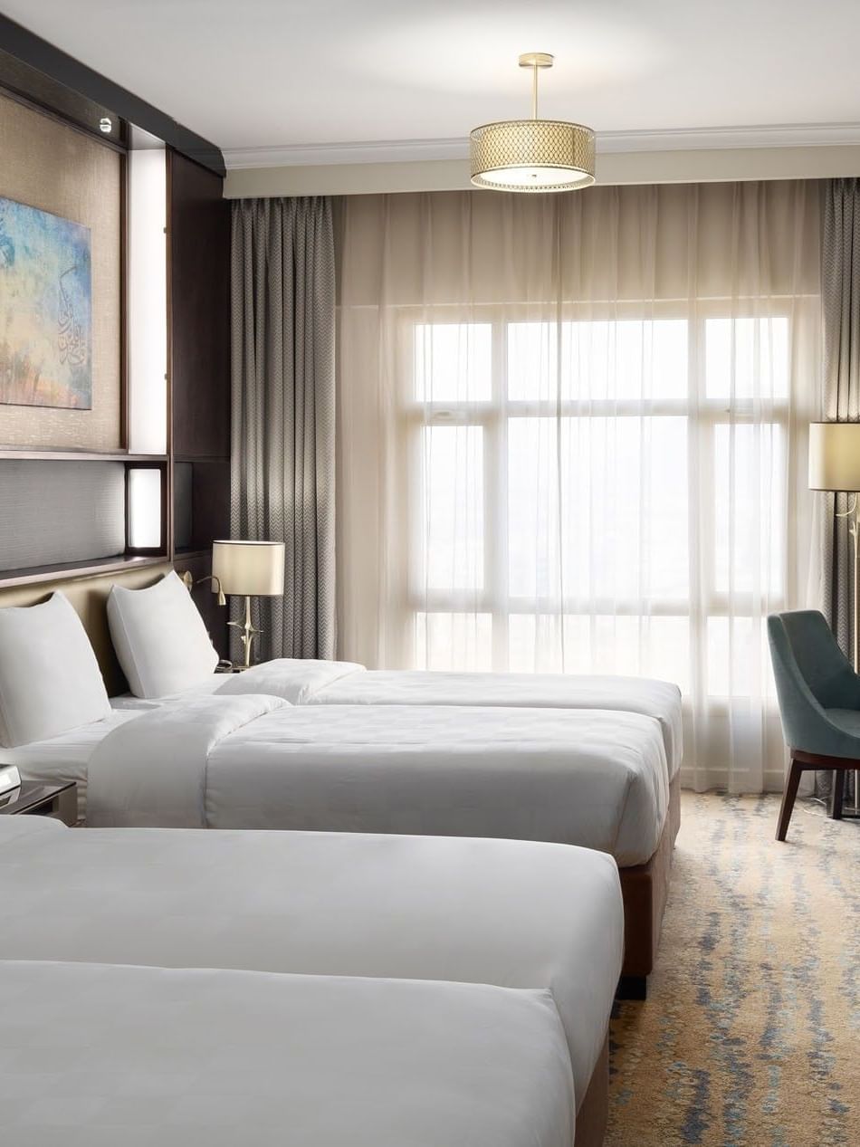 غرفة تنفيذية بسريرين في فندق سجى ووريك المدينة، تضم سريرين منفصلين، منطقة عمل، تلفاز بشاشة مسطحة، وإضاءة طبيعية من نافذة كبيرة مع ستائر.