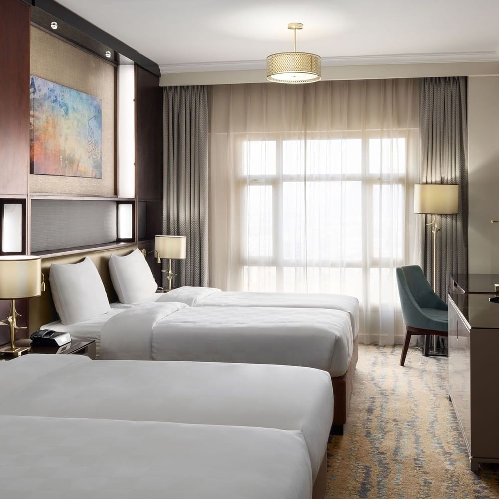 غرفة تنفيذية بسريرين في فندق سجى ووريك المدينة، تضم سريرين منفصلين، منطقة عمل، تلفاز بشاشة مسطحة، وإضاءة طبيعية من نافذة كبيرة مع ستائر.