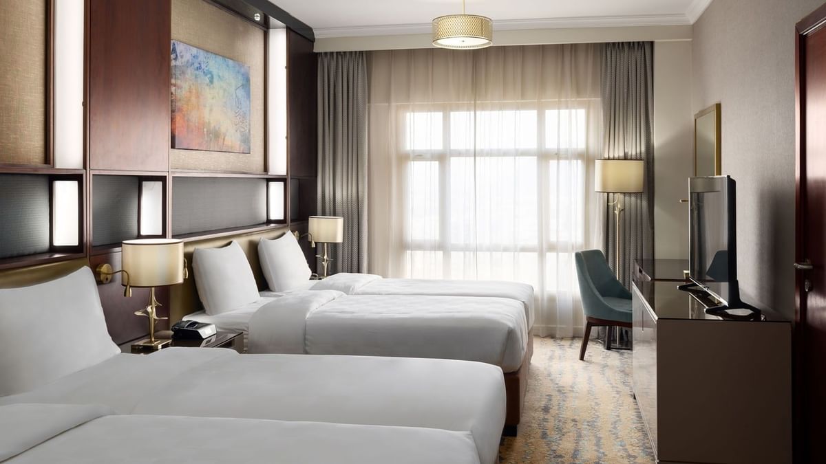 غرفة تنفيذية بسريرين في فندق سجى ووريك المدينة، تضم سريرين منفصلين، منطقة عمل، تلفاز بشاشة مسطحة، وإضاءة طبيعية من نافذة كبيرة مع ستائر.