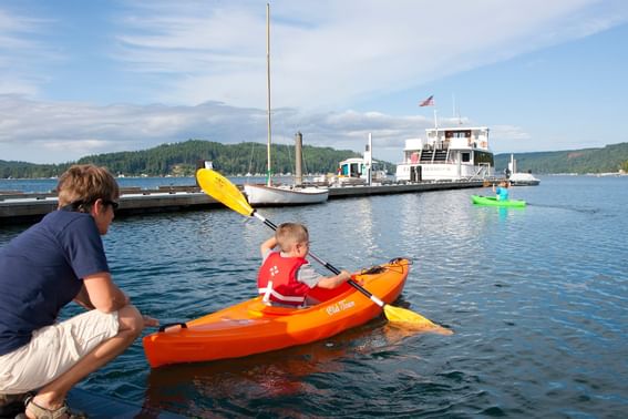 A kid paddling on a small boat in the Canal at Alderbrook