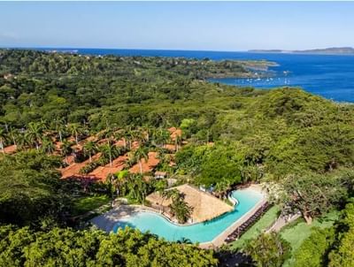 Aerial view of the Villas Sol Beach Resort and the sea around with trees