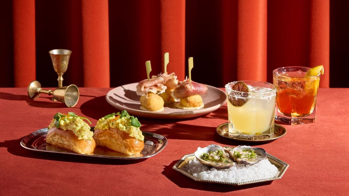 Appetizers and cocktails on a red table served in Fields Restaurant at Crown Hotel Melbourne