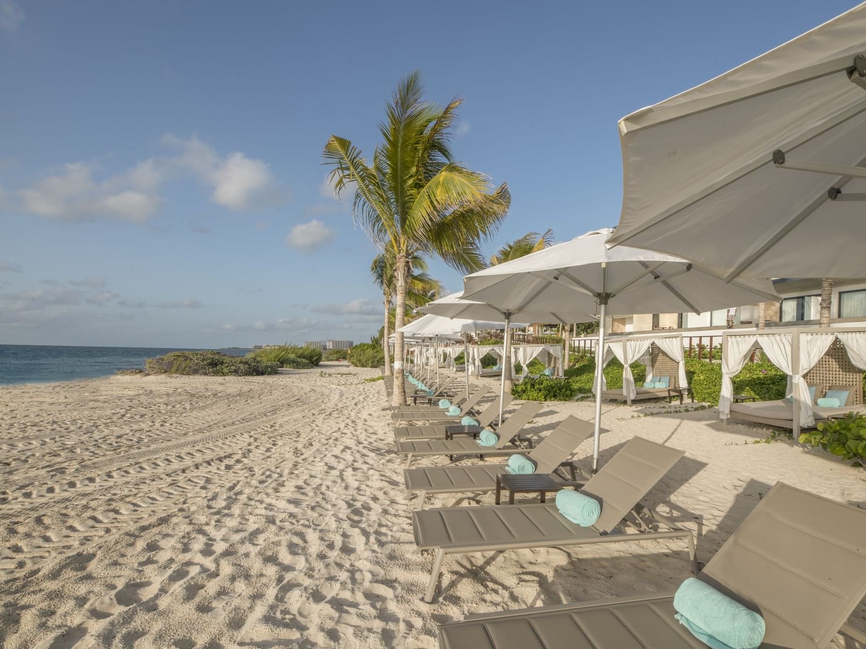 Sunloungers with canopies on the beach at Haven Riviera Cancun