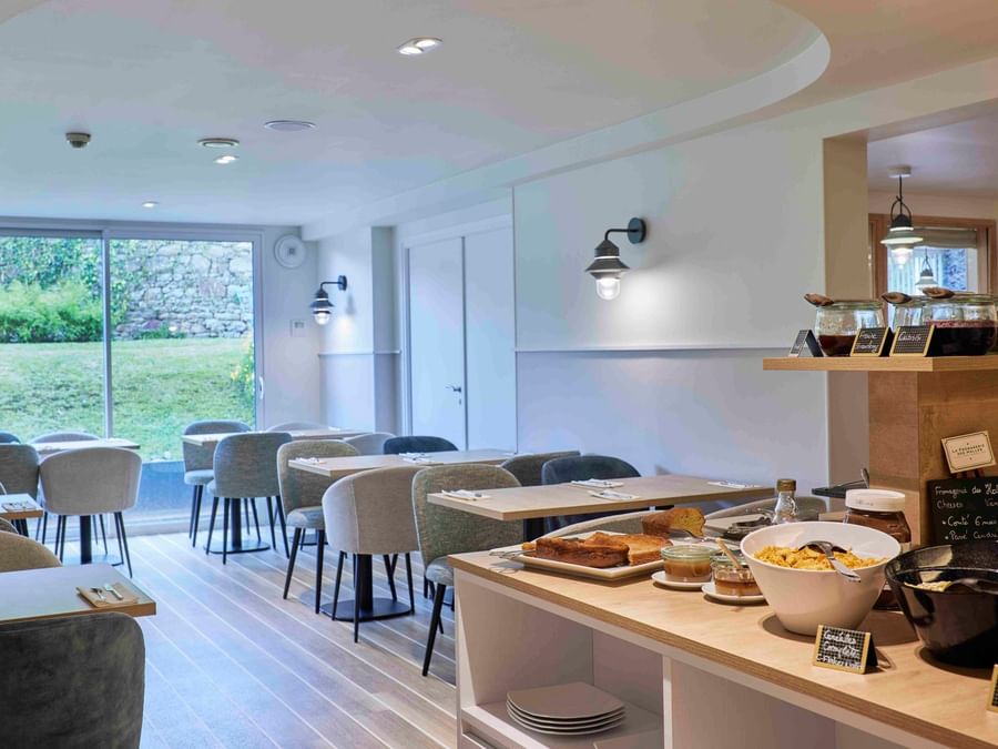 Salle à manger élégante avec vue sur le jardin à Hôtel La Marébaudière.