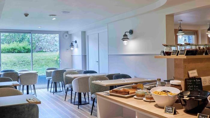 Salle à manger élégante avec vue sur le jardin à Hôtel La Marébaudière.