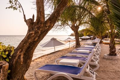 Comfy loungers and tents arranged on the seashore by the sea near Hotel Isla Del Encanto