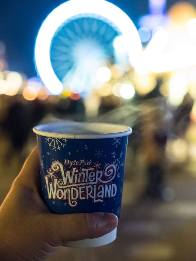 A hand holding a cup of coffee at the Hyde Park Christmas market