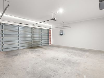 Empty garage with brick wall and metal garage door at La Trobe University Regional Housing – Mildura.