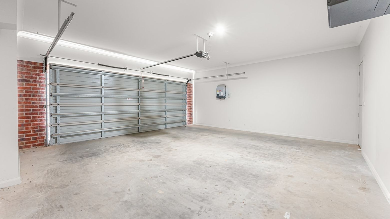 Empty garage with brick wall and metal garage door at La Trobe University Regional Housing – Mildura.