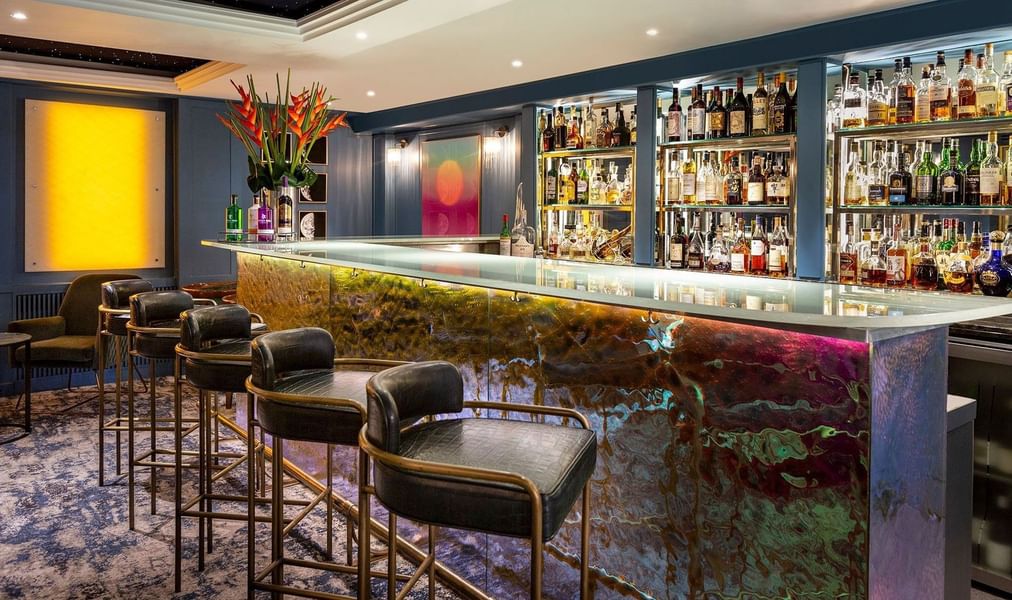 Capital Bar featuring dark leather stools placed by a glowing counter at The Capital Hotel, Apartments and Townhouse