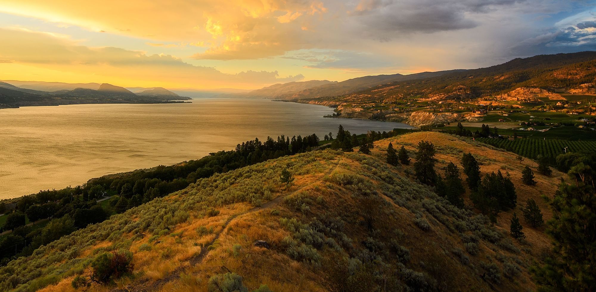 Scenic view of Okanagan Lake surrounded by rolling hills and mountains near Coast Penticton Hotel