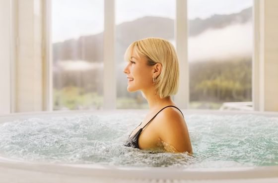 Woman enjoying the whirlpool at IMLAUER Hotel Schloss Pichlarn