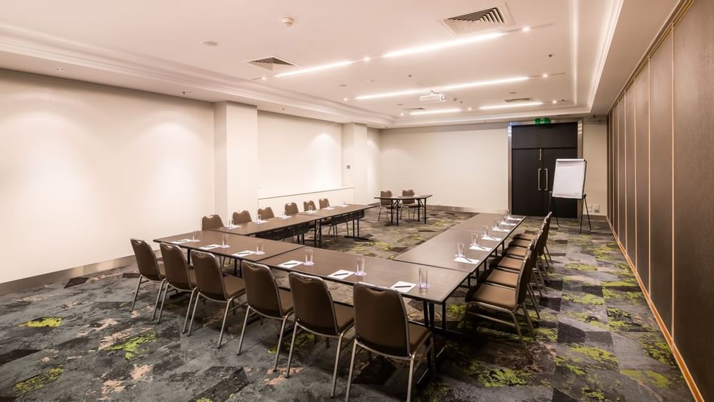 U-shape table setup under ceiling lighting and carpet floors in Protea at Novotel Sydney International Airport