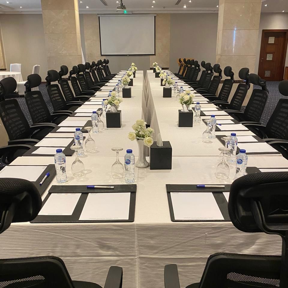 قاعة اجتماعات «كريستال» بتصميم على شكل حرف U، مزودة بطاولة وكراسي وزينة زهور وسط الطاولة ودفاتر ملاحظات في فنادق ومنتجعات وارويك