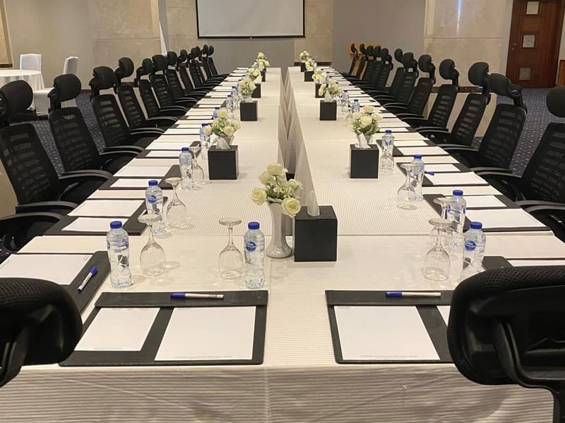 قاعة اجتماعات «كريستال» بتصميم على شكل حرف U، مزودة بطاولة وكراسي وزينة زهور وسط الطاولة ودفاتر ملاحظات في فنادق ومنتجعات وارويك