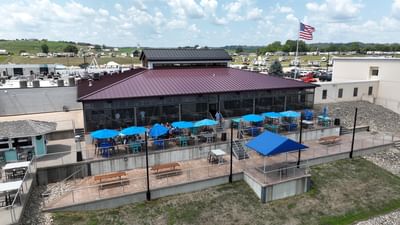 Off Shore Bar & Grill with outdoor seating under blue umbrellas, surrounded by rolling hills at Off Shore Resort