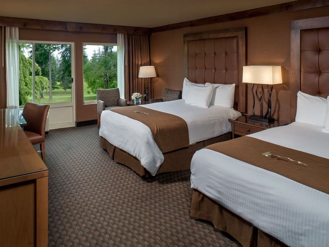 two beds and chairs in a hotel room