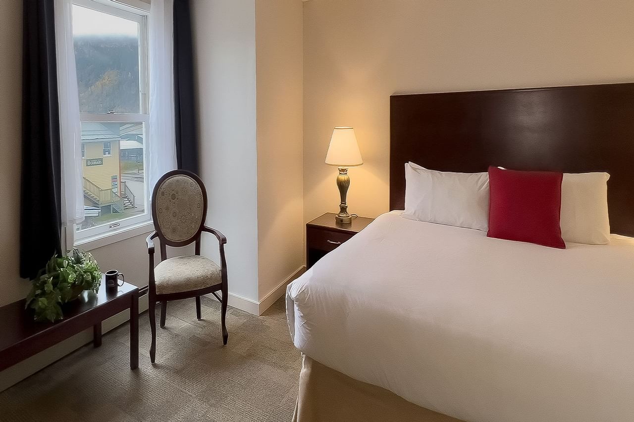 Guest room with large bed, chair, window view