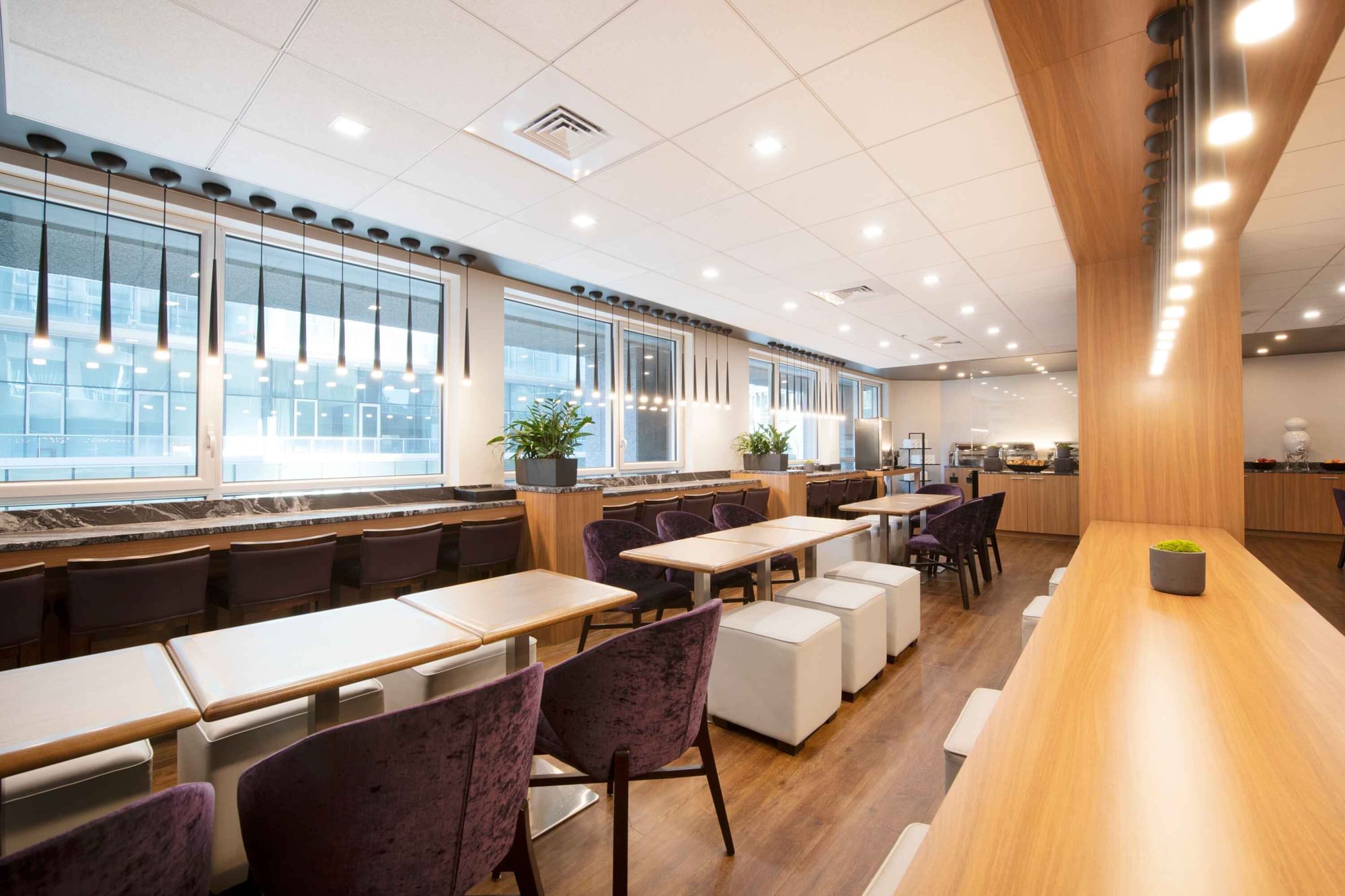 Stylish lounge or breakfast area at Warwick Hotels and Resorts with long communal tables and bar seating