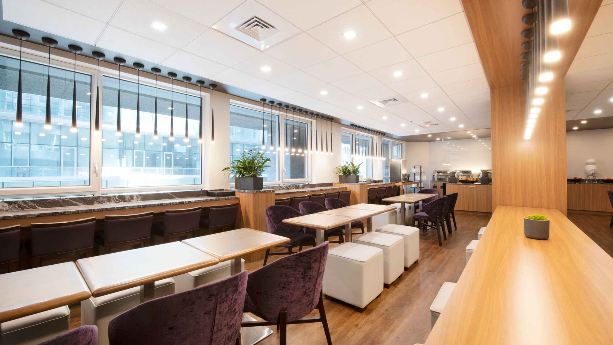 Stylish lounge or breakfast area at Warwick Hotels and Resorts with long communal tables and bar seating