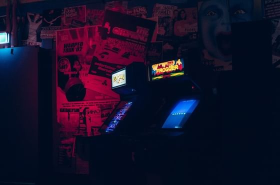 Illuminated arcade games in a dimly lit room with vintage concert posters on the walls at Showboat Hotel & Resort Atlantic City