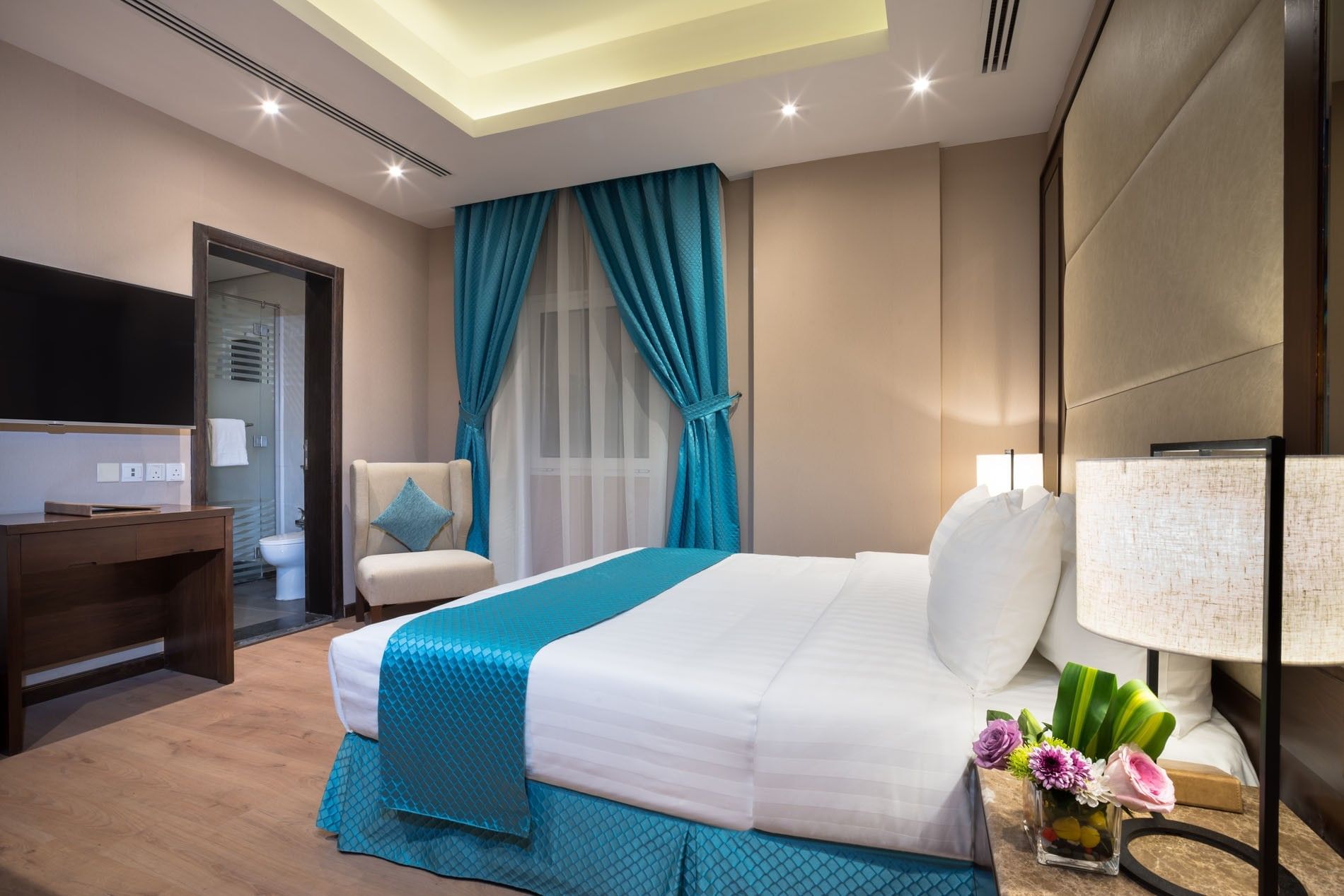 TV facing bed with side tables near window in Standard room at Naviti By Warwick Dammam