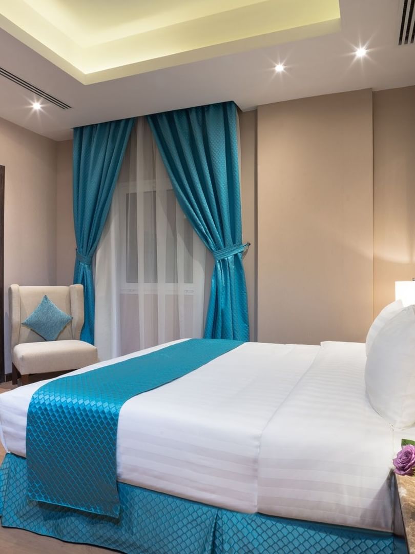 TV facing bed with side tables near window in Standard room at Naviti By Warwick Dammam