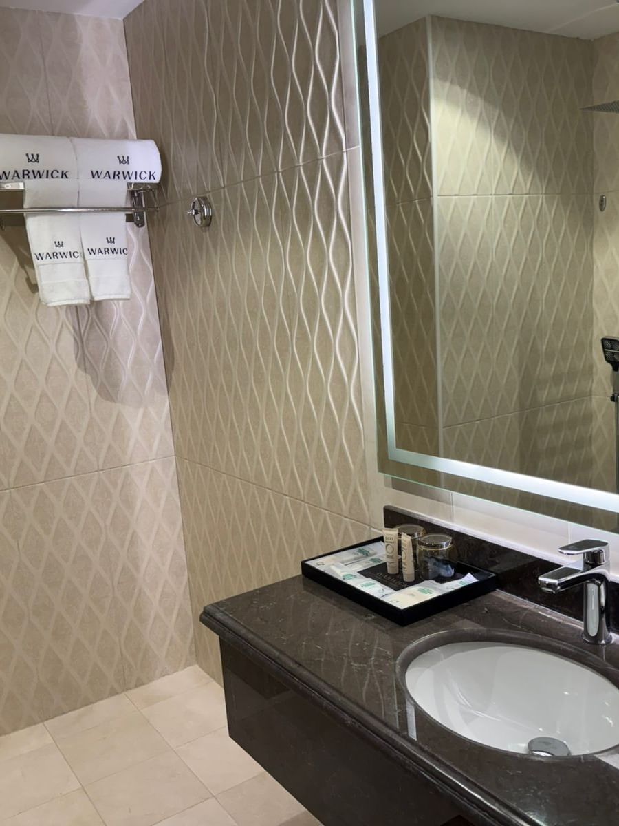 Ambassador Suite bathroom featuring a vanity with an integrated sink under a mirror at Warwick Jeddah Hotel & Spa
