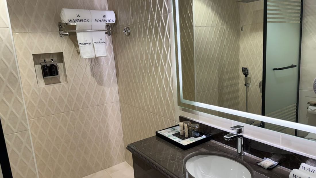 One Bedroom Suite featuring a vanity with a mirror and a towel rack at Warwick Jeddah Hotel & Spa
