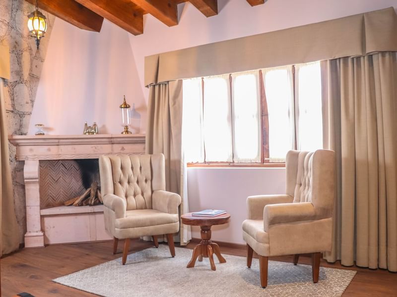 Fireplace & ancient chairs in the Deluxe Room at Gamma Hotels