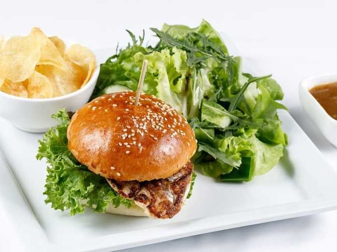 A burger & salad served in In-Room Dining at Chatrium Hotels