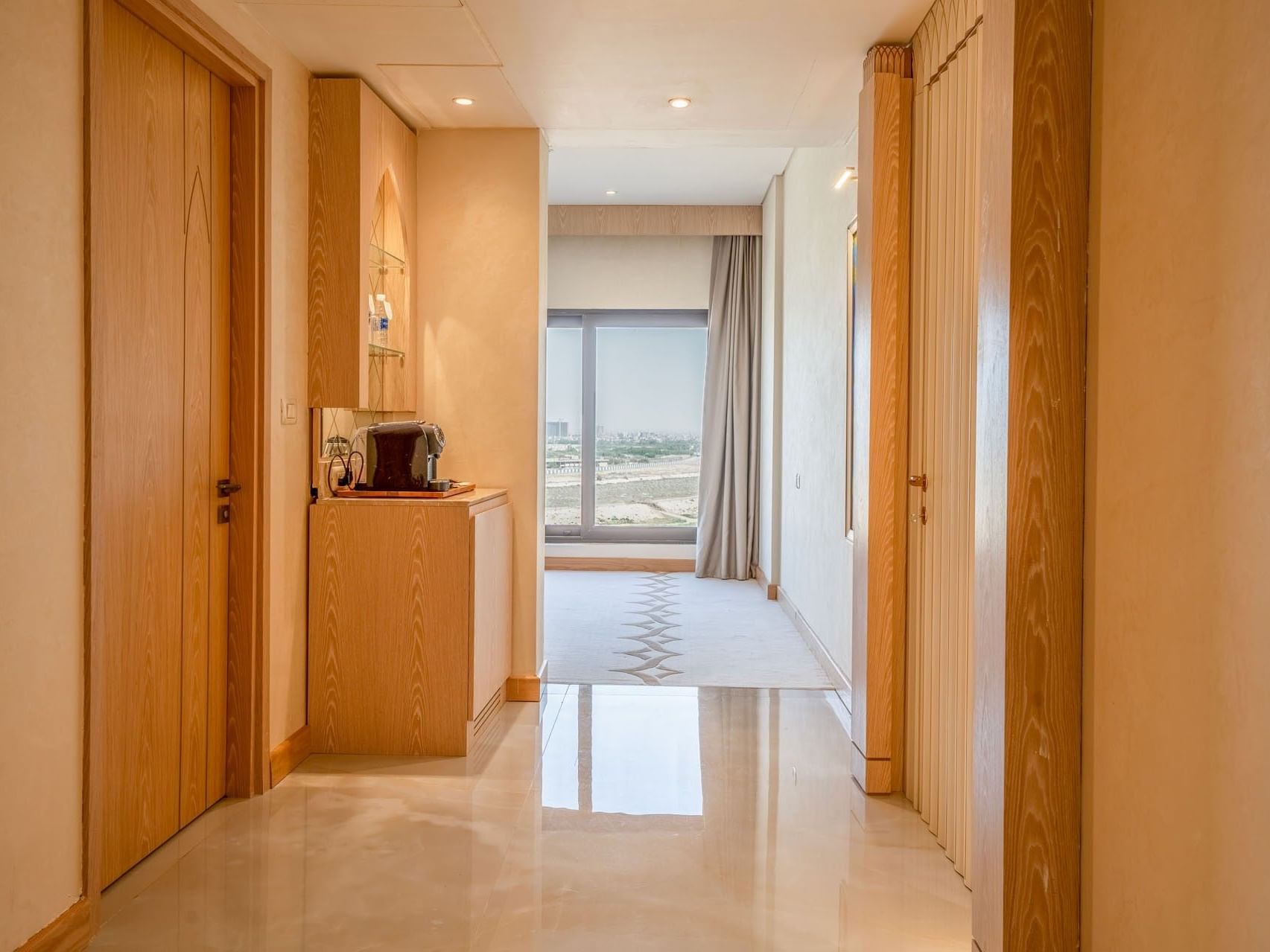 Elegant hotel corridor with wooden doors and bright ceiling lights at World Heart Hotel Baghdad.