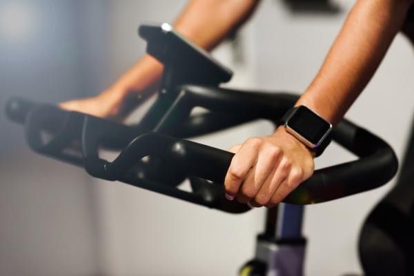 Close-up of a person cycling on a stationary bike at the gym training for the Wokingham Bikeathon.