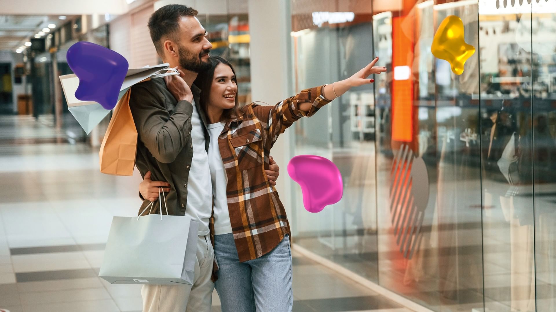 Couple with shopping bags walking through a mall near Real Inn Tijuana