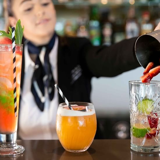 Bar tender pouring drinks in to the glass in Shallows Bar at Pullman Magenta Shores